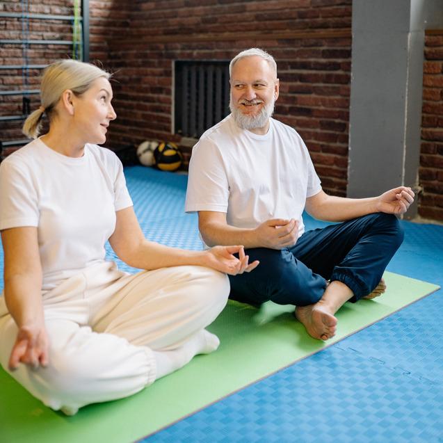 Zwei sich freundlich anschauende Sportler im Schneidersitz